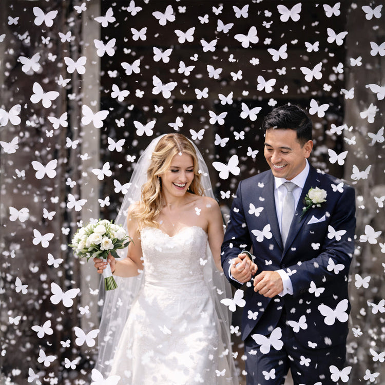 Novios saliendo de la ceremonia rodeados de confeti blanco en forma de mariposas, ideal para bodas y sesiones de fotos.